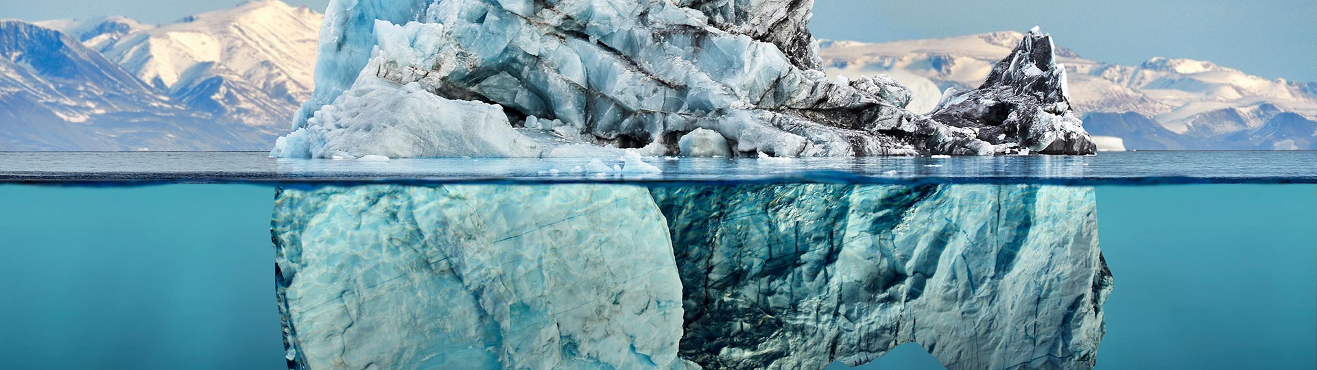 A large iceberg with reflection in a calm blue sea