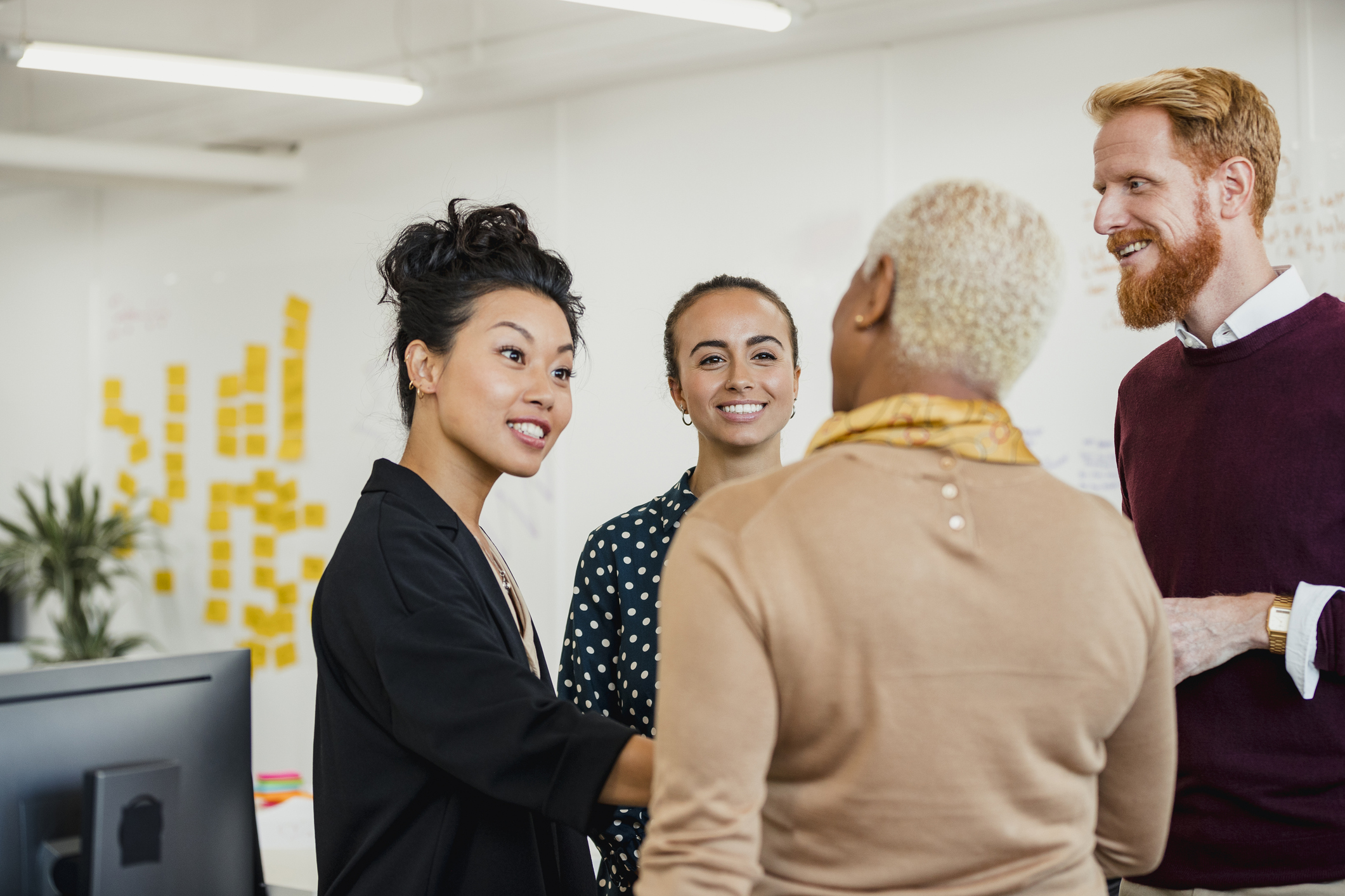 A group of people having a conversation in an office setting