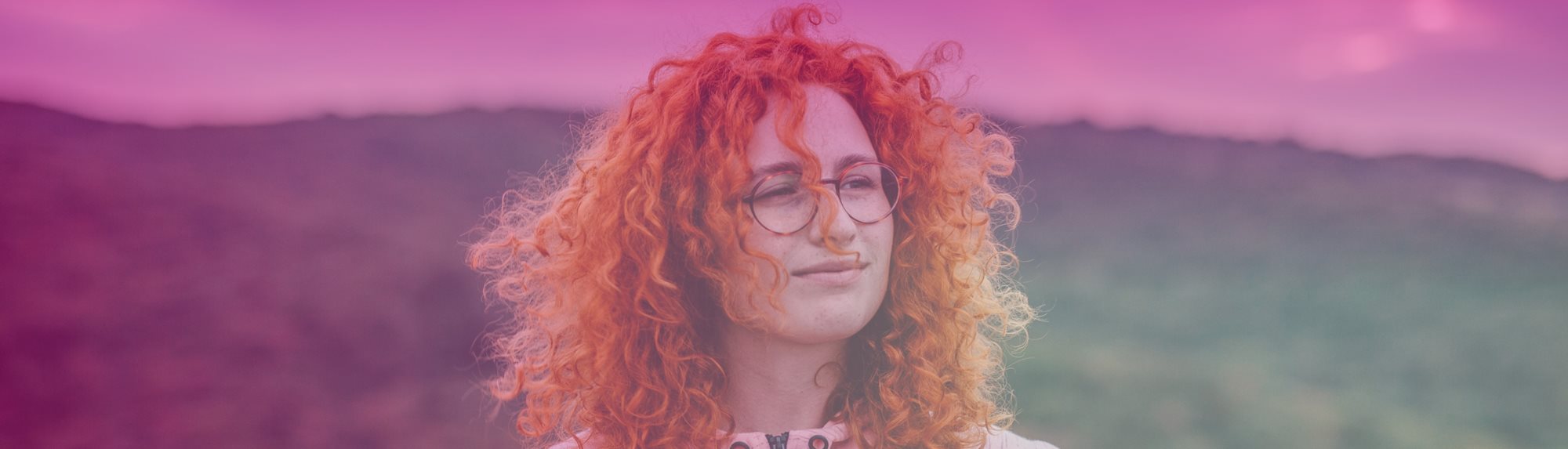 A woman's face with a hillside in the background