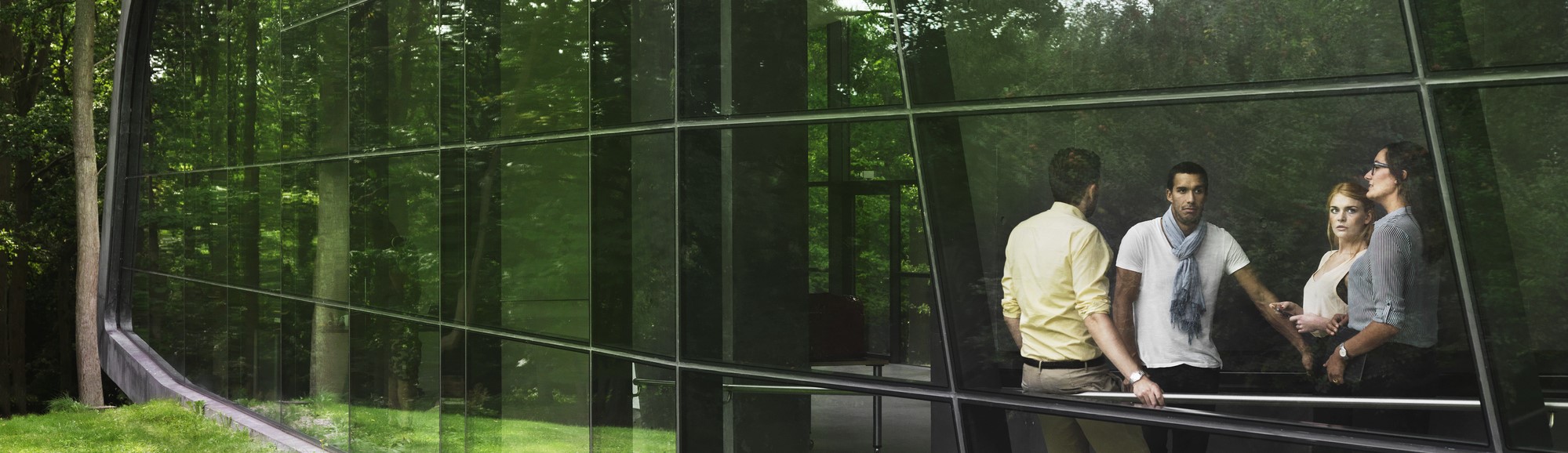 A group of people in a modern building in a green natural setting