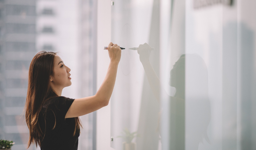 Young woman writing on whiteboard