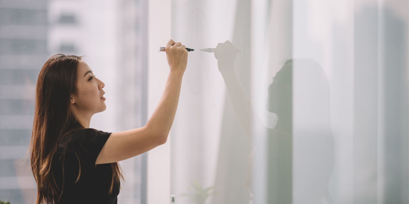 Young woman writing on whiteboard