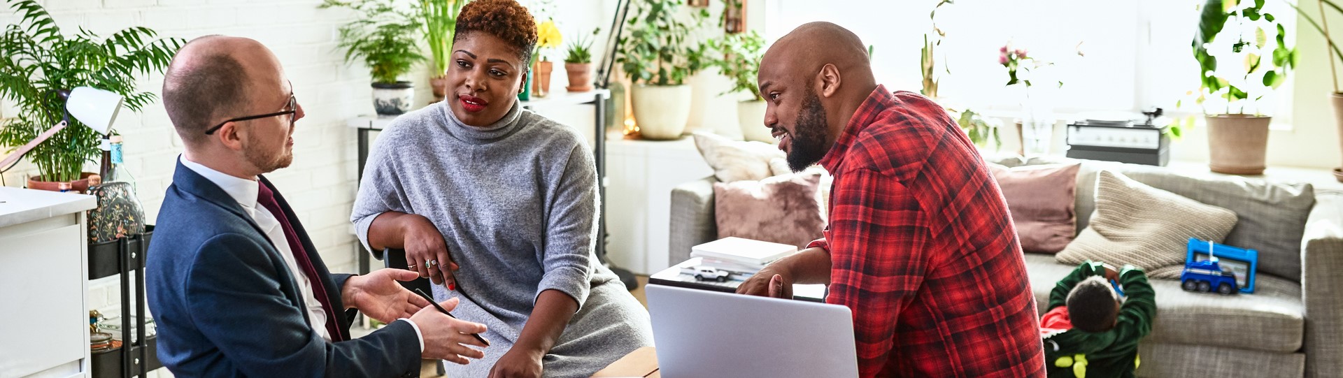 A couple in their home in discussion with a business advisor