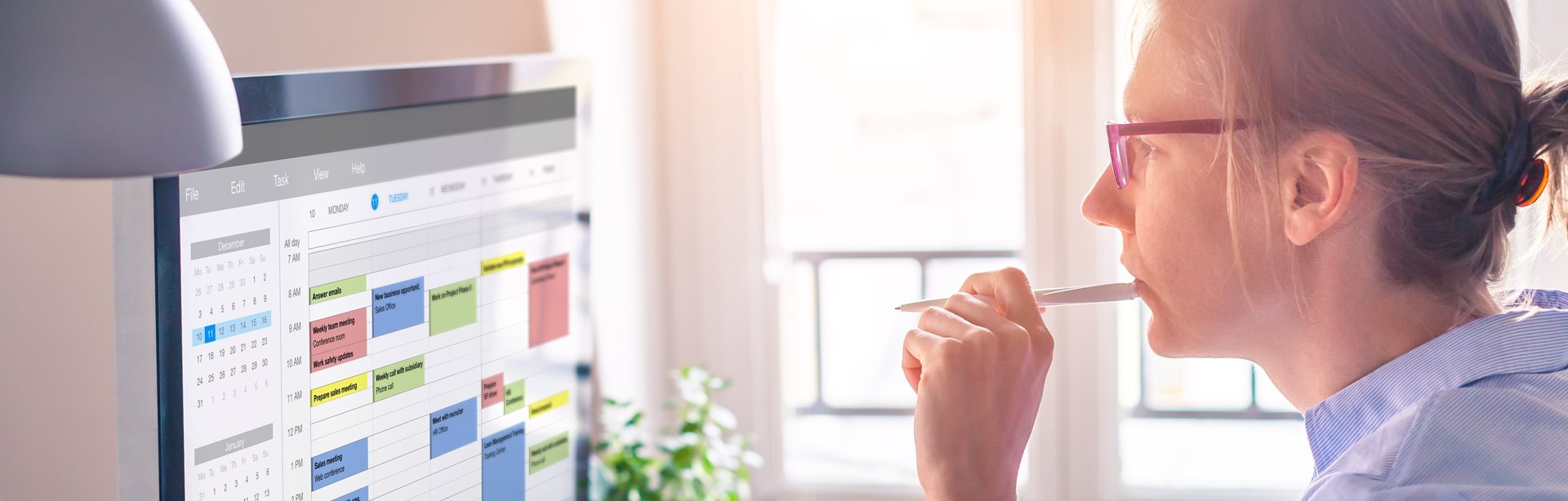 A thoughtful woman staring at the digital calendar on her computer screen
