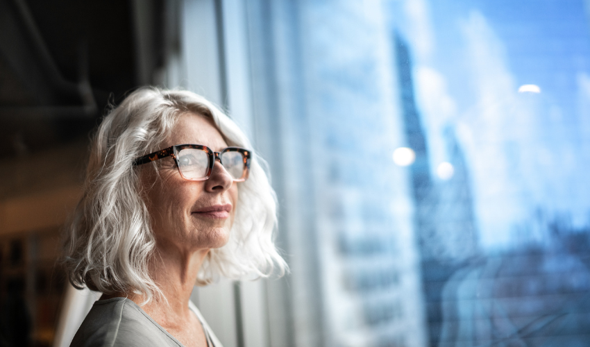 Mature business woman looking out window