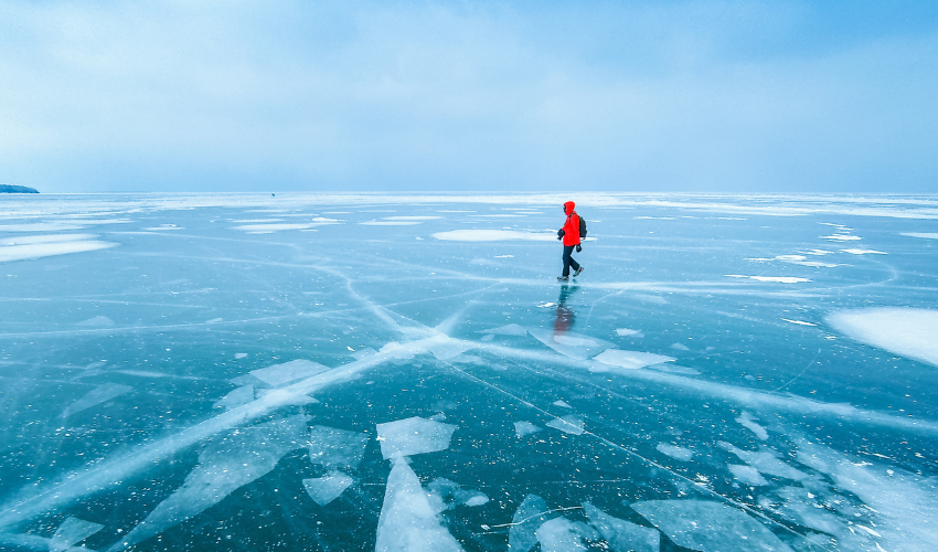 Man walking across frozen lake
