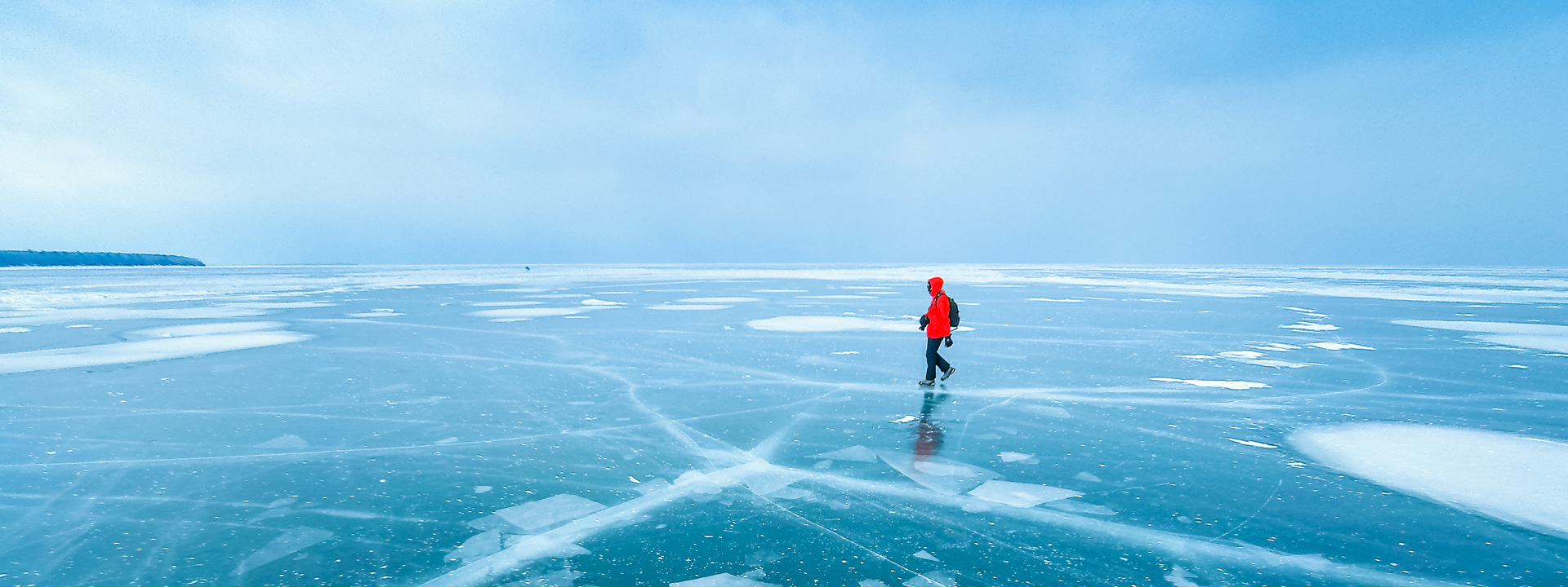 Man walking across frozen lake