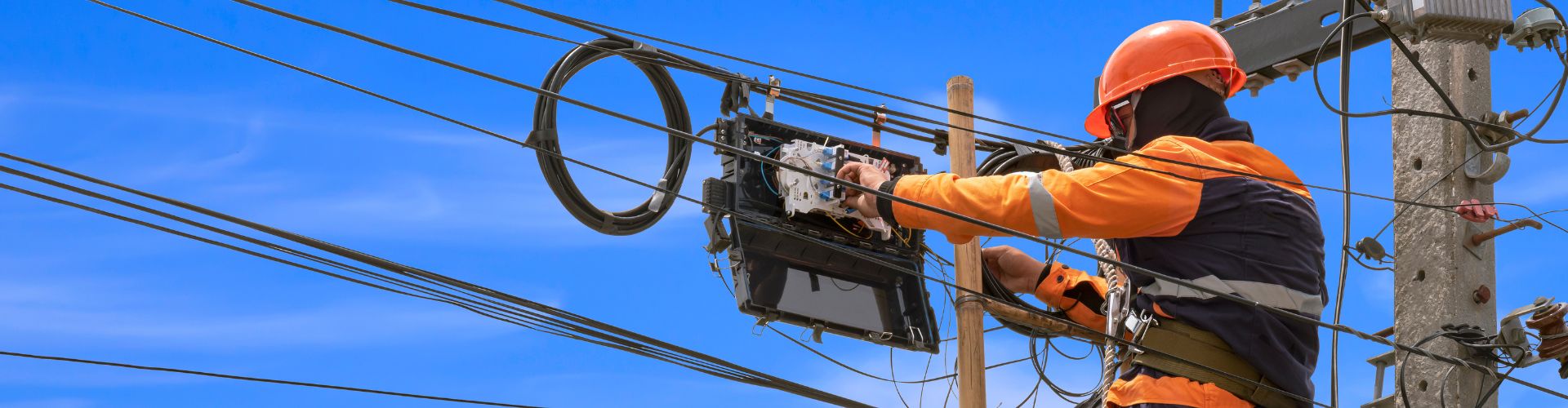 Ein Mann arbeitet an Stromleitungen. 