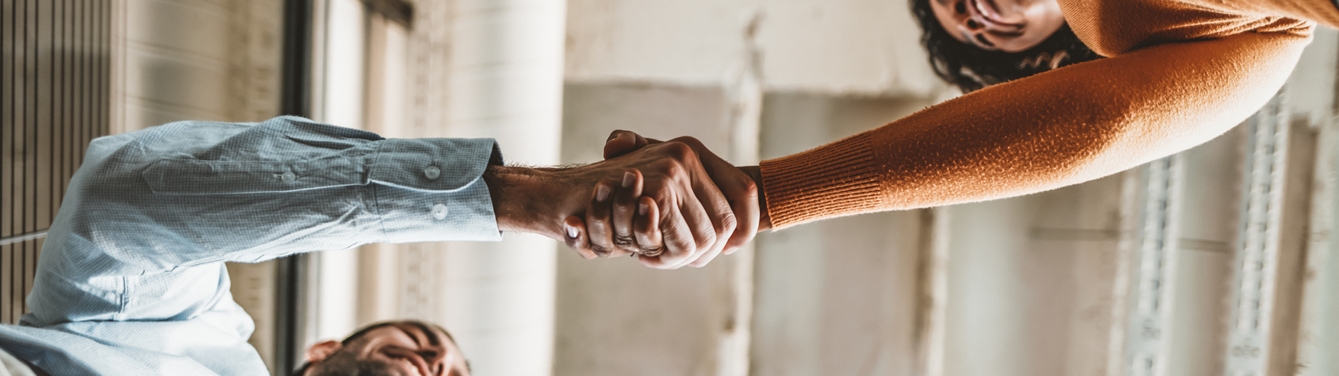 A view from below of two people shaking hands