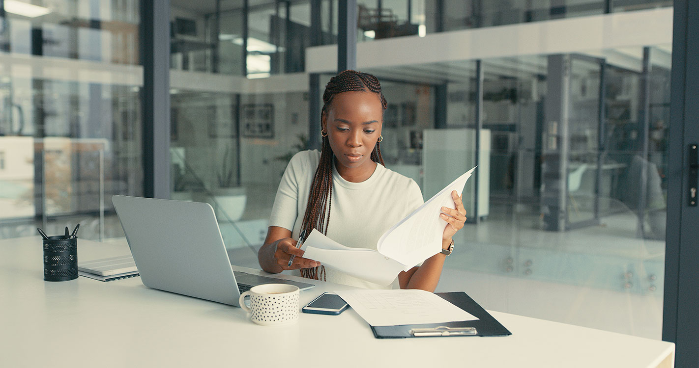 A woman at her office desk looking at reports