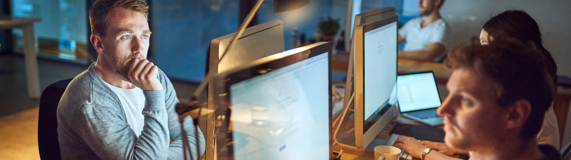A man deep in thought while looking at a computer
