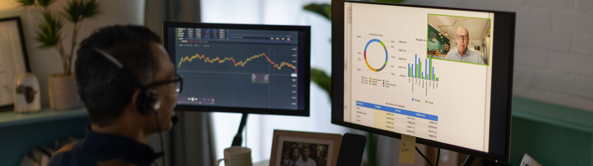 A man with a headset on an internet call looking at two screens