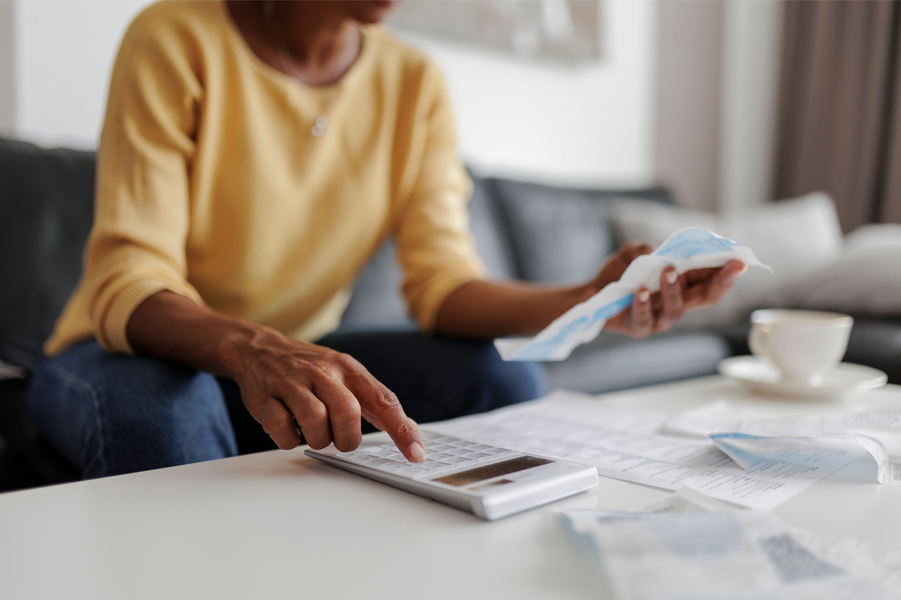 Woman using a calculator while looking at her bills