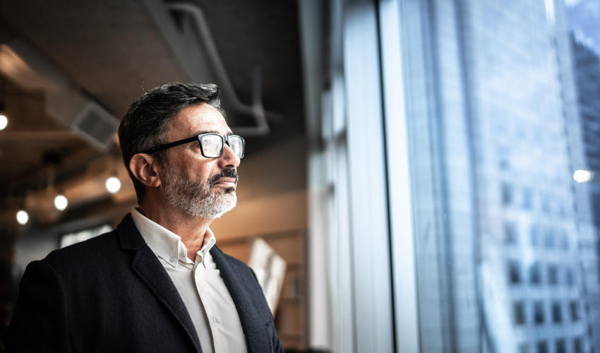 Business man wearing glasses looking out of window