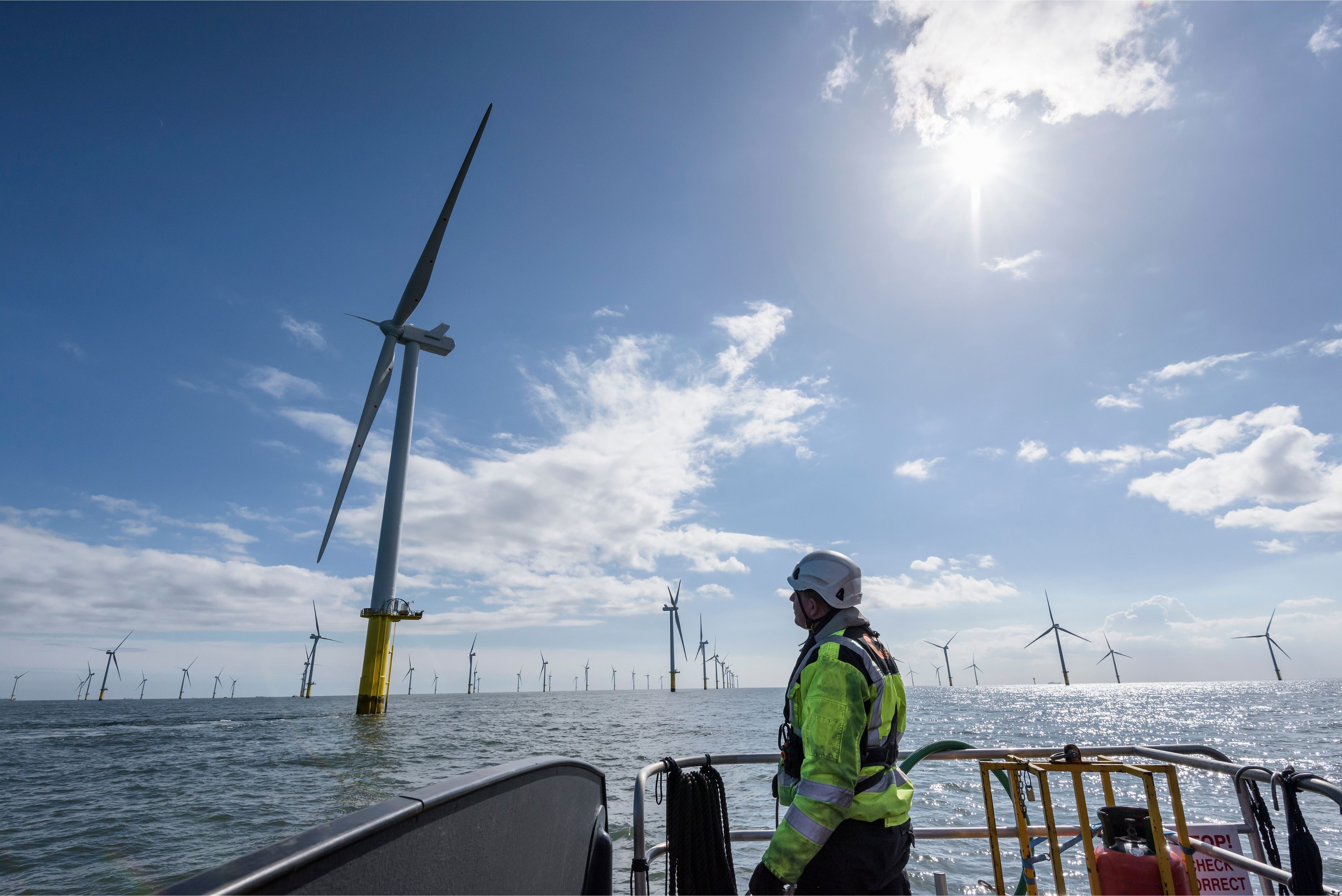 Worker on a boat inspecting an offshore wind farm