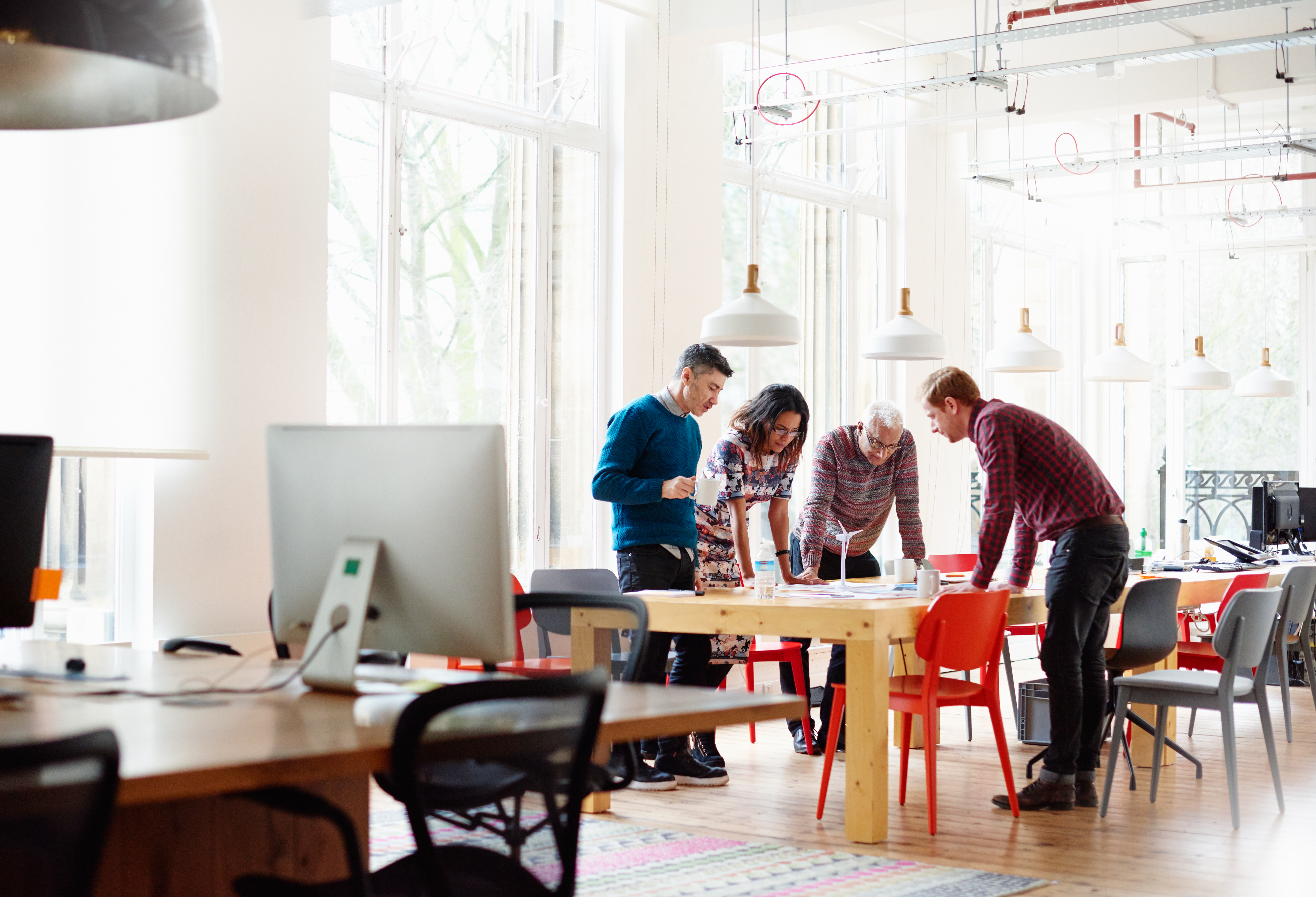 Group of people together at a table in an office