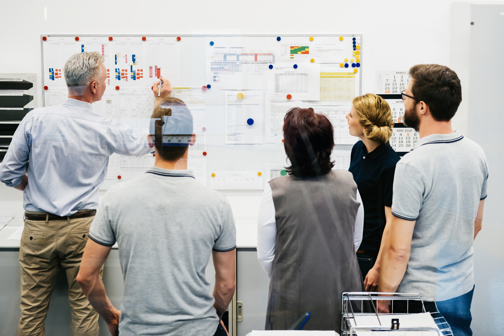 A man writing on data sheets pinned on a whiteboard