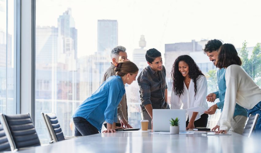 Group of people smiling mid meeting in a high rise building