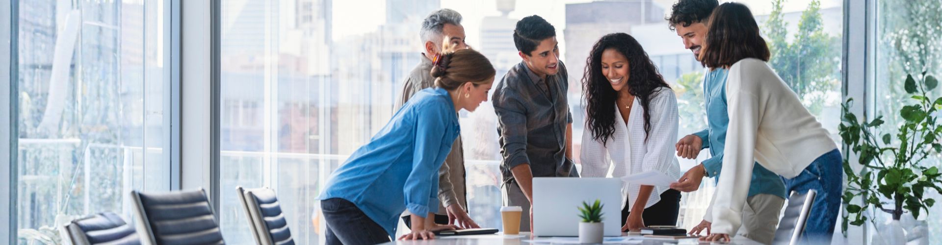 Group of people smiling mid meeting in a high rise building