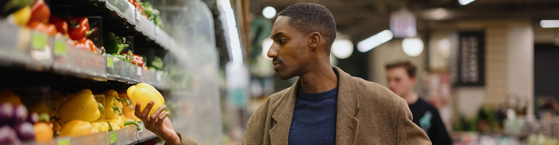 Man Shopping for Fresh Produce in a Supermarket Aisle