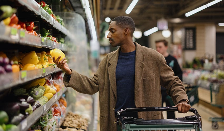 Man Shopping for Fresh Produce in a Supermarket Aisle