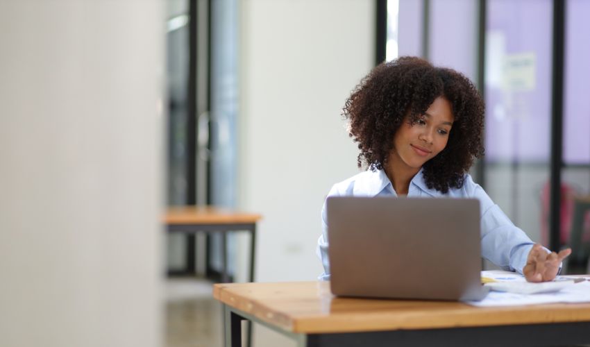 Woman smiling and looking at her laptop