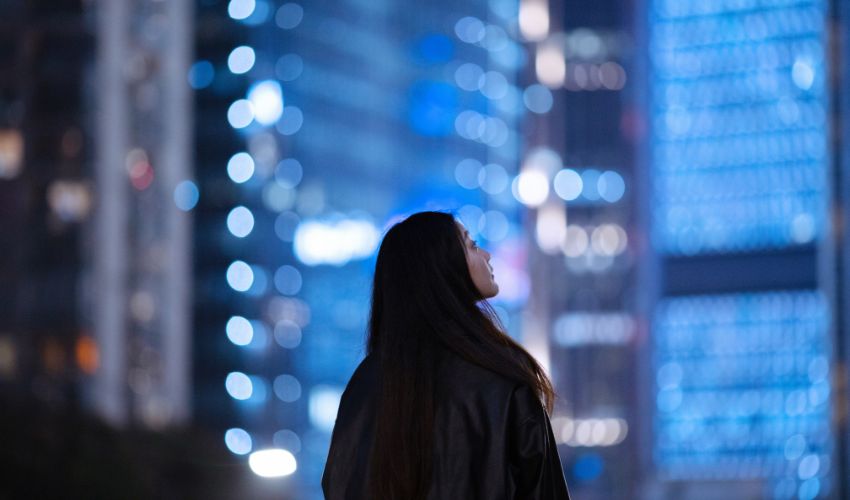 Woman looking up at buildings