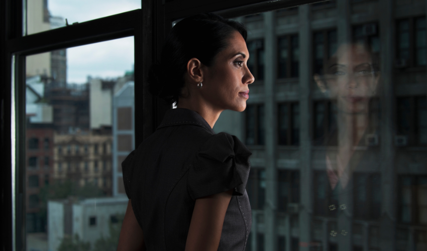 Woman looking over city, reflected in window