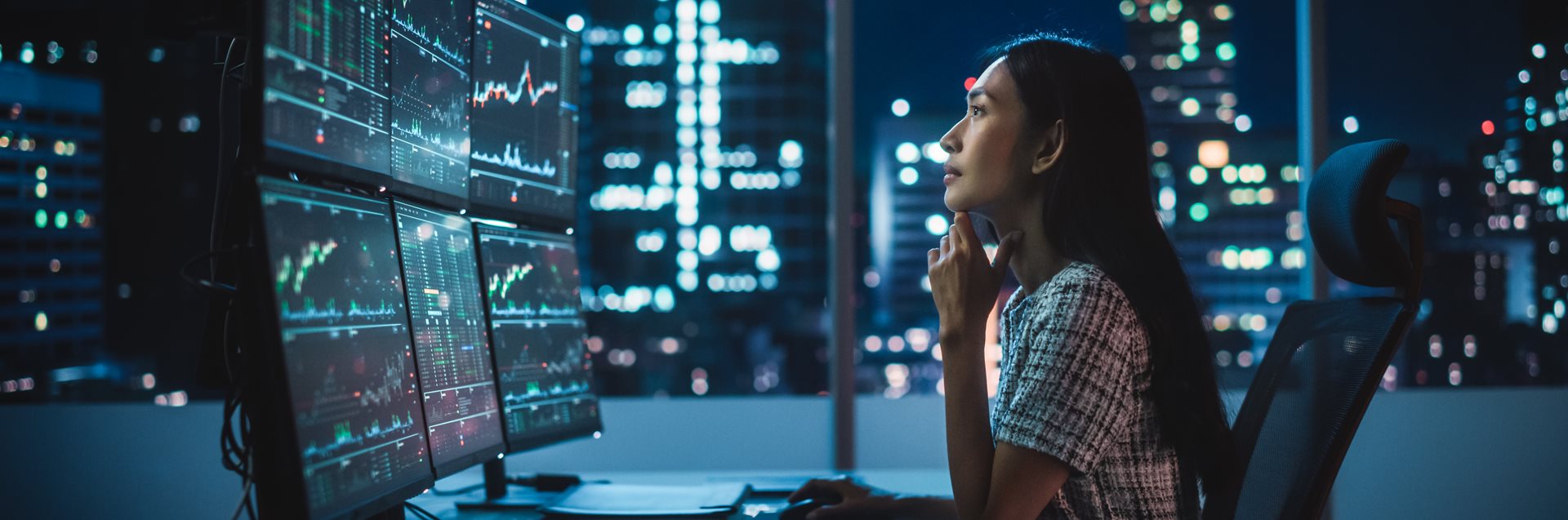 A woman looking at data on multiple screens
