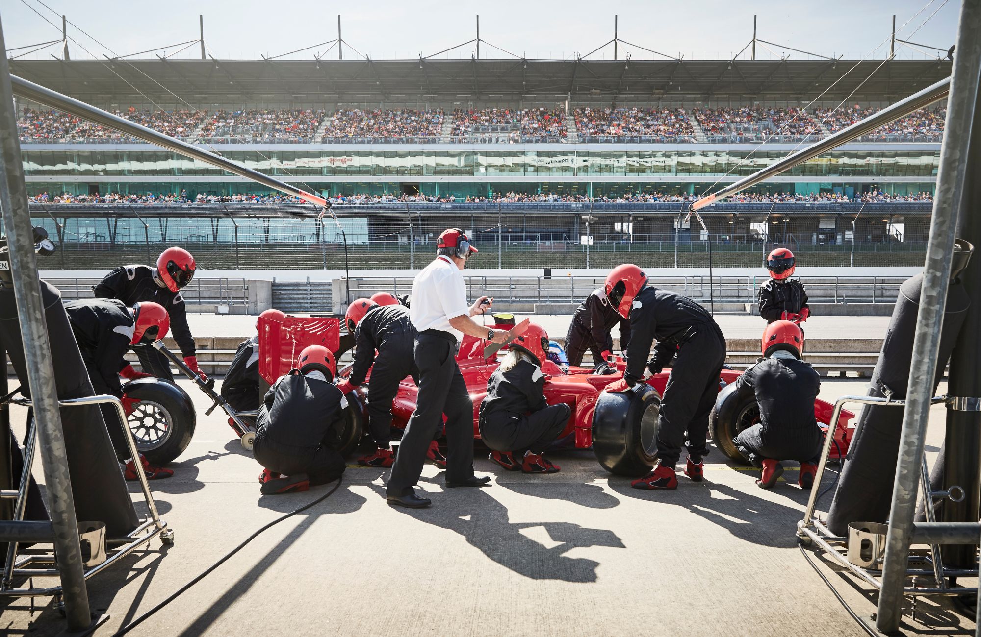 Pit crew replacing tires on race car