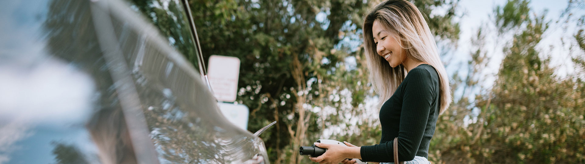 A woman charging her electric car