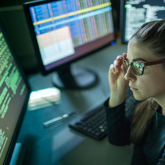 A woman with glasses looking at a computer screen