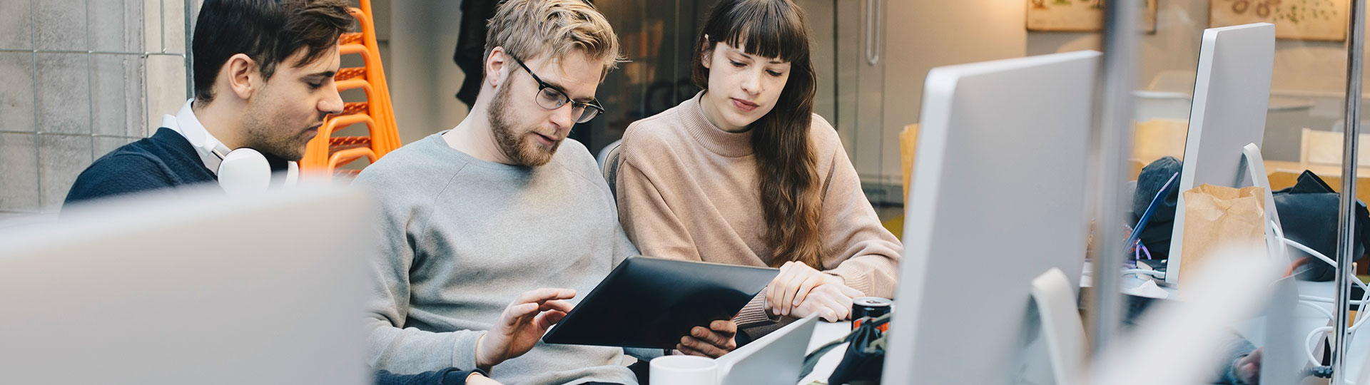 Three colleagues looking at a tablet