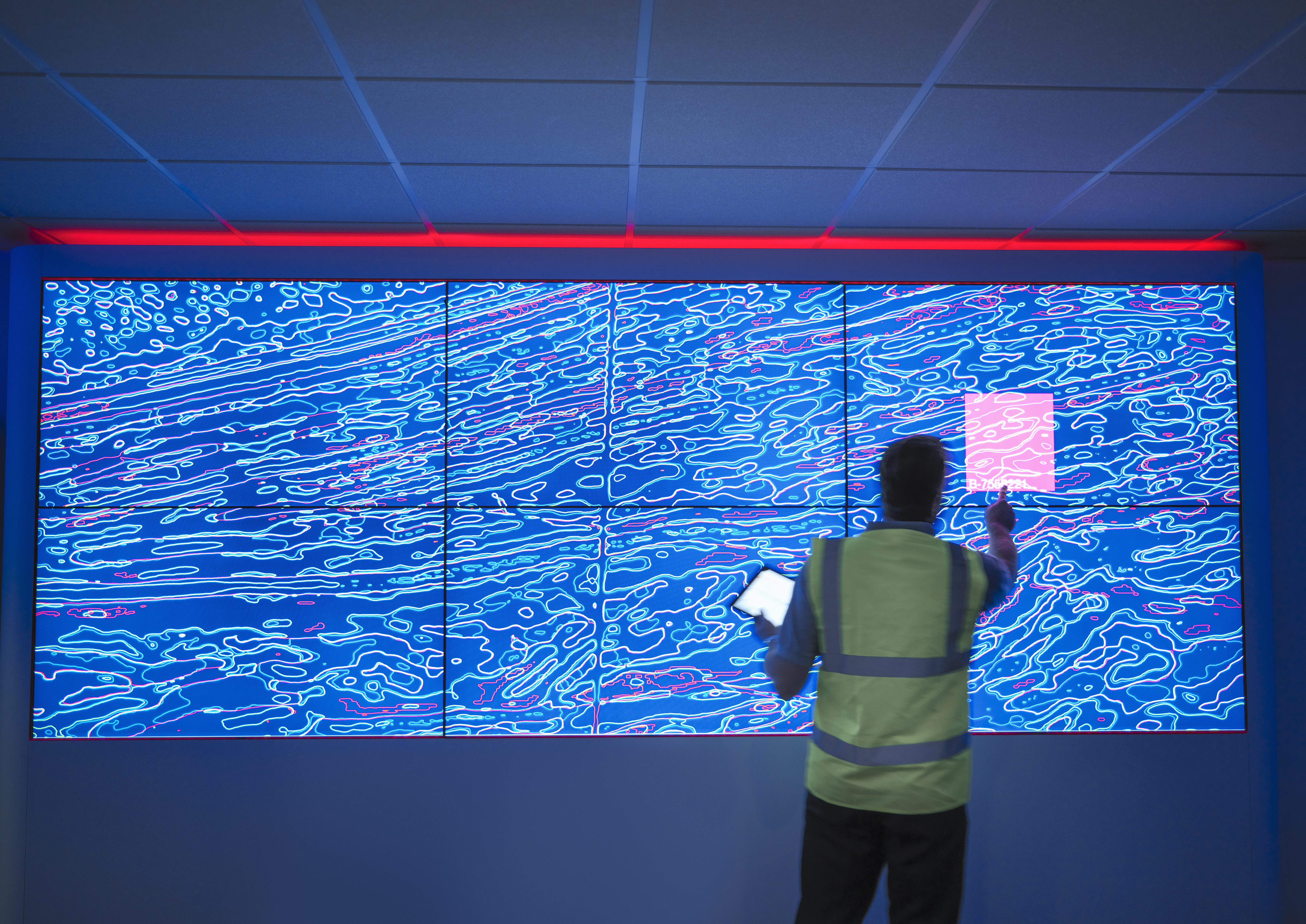 A man pressing a large interactive screen