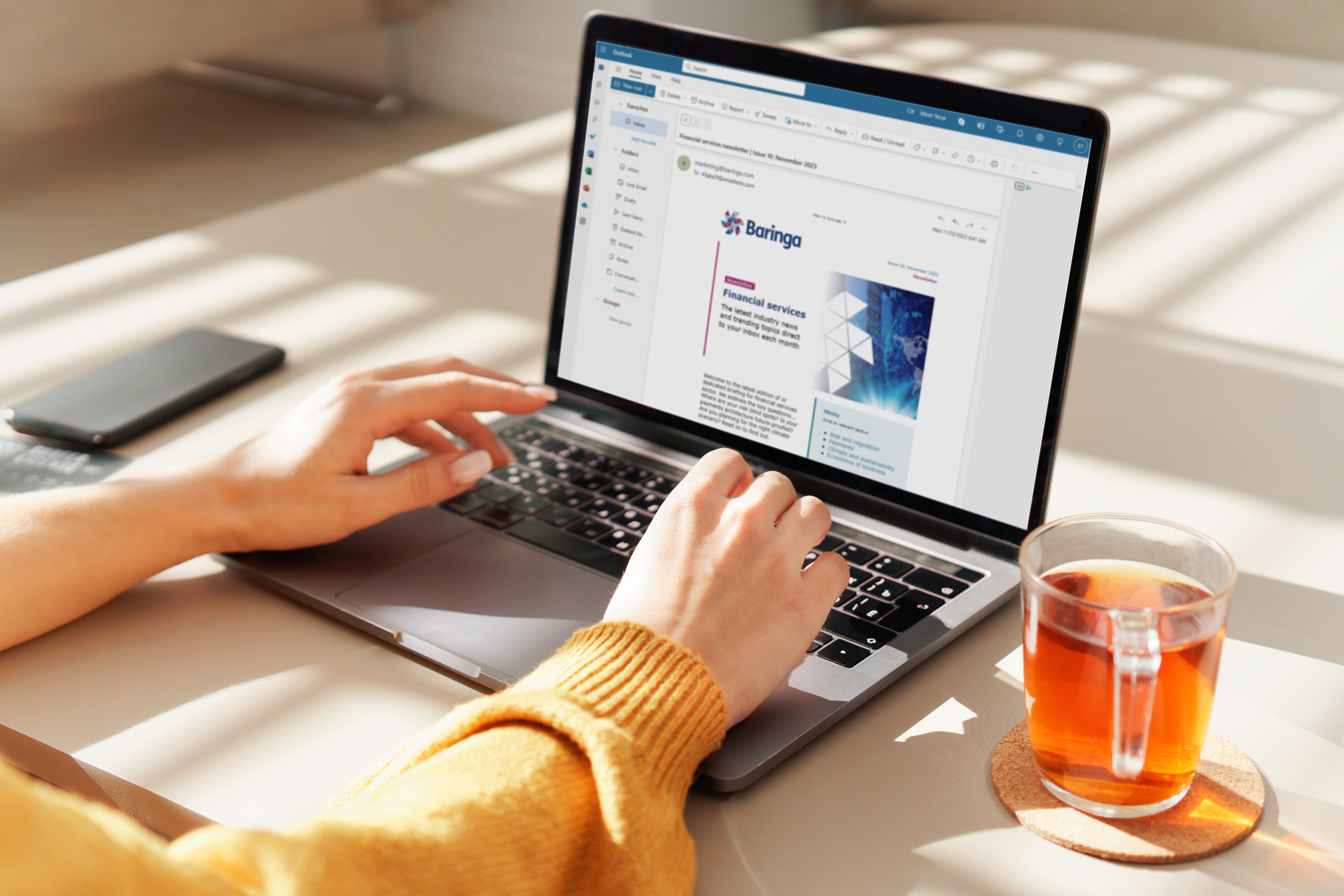 Hands at laptop showing Baringa website