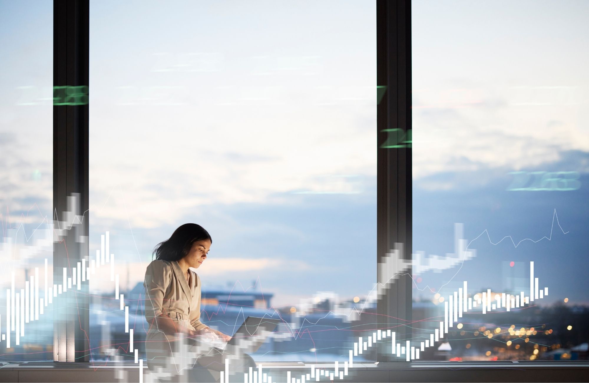 Financial specialist working on laptop with city skyline behind her and graphs surrounding her