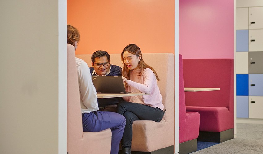 A Baringa team sitting in a meeting both with laptop