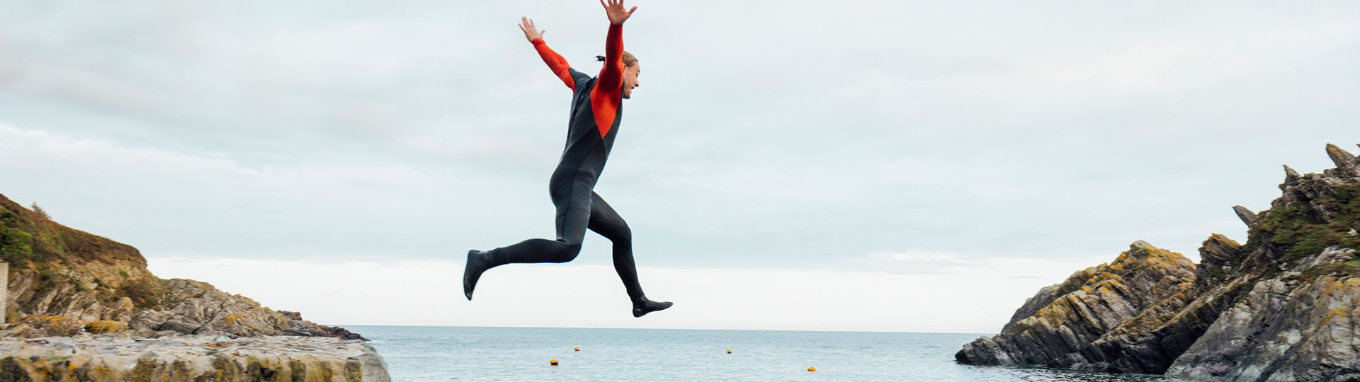 A person jumping from a harbour wall into the sea