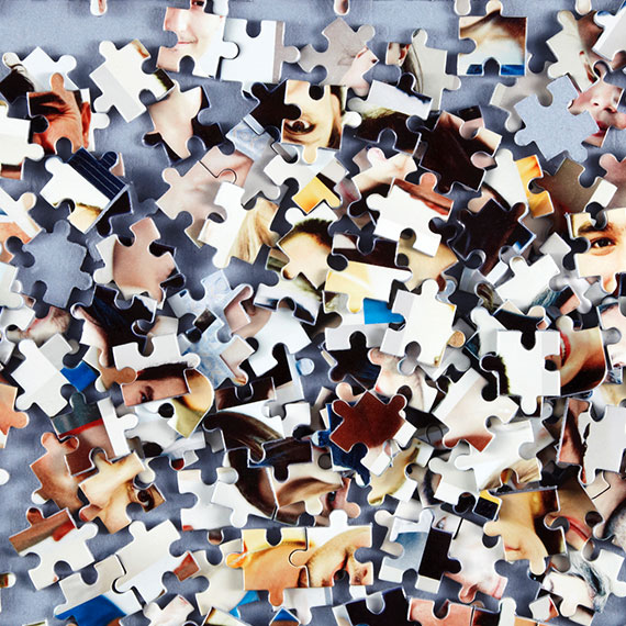Disassembled jigsaw pieces showing aspects of the human face