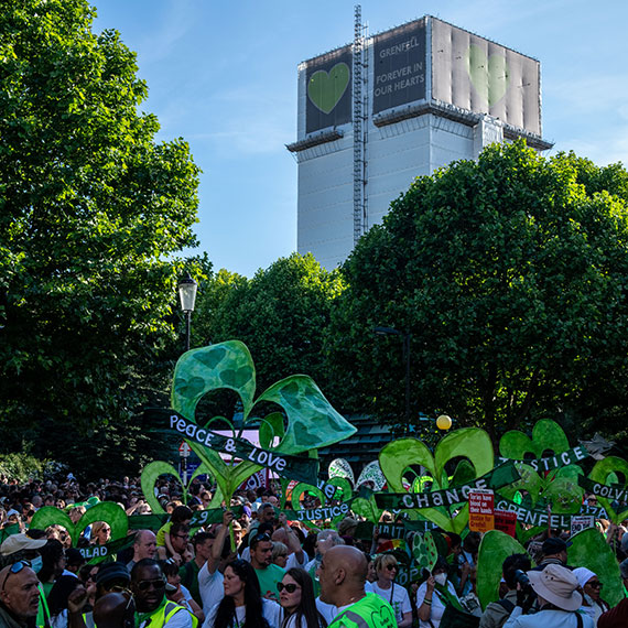 A rally seeking justice for Grenfell with the tower behind showing a huge green heart