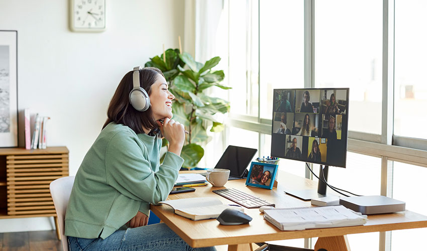 Smiling businesswoman discussing with colleagues through video call