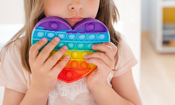 Child holding a rainbow coloured heart