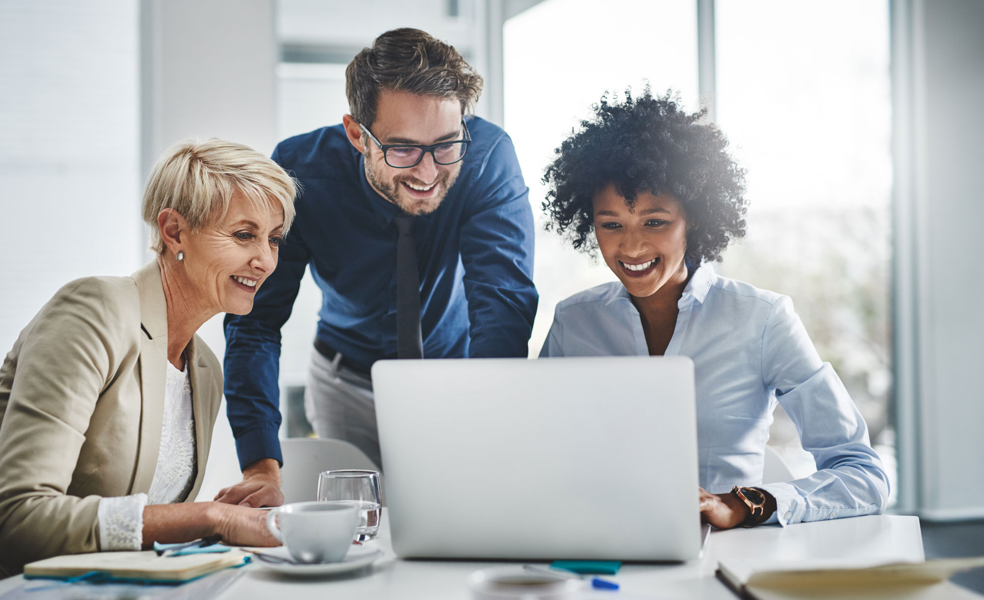 Three people working together on a laptop