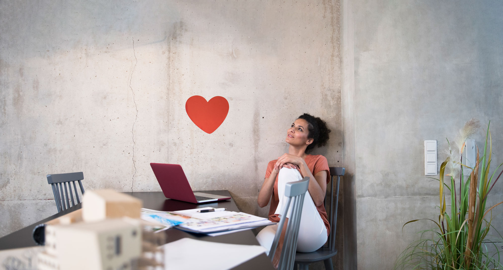Woman working at a table looking at a heart