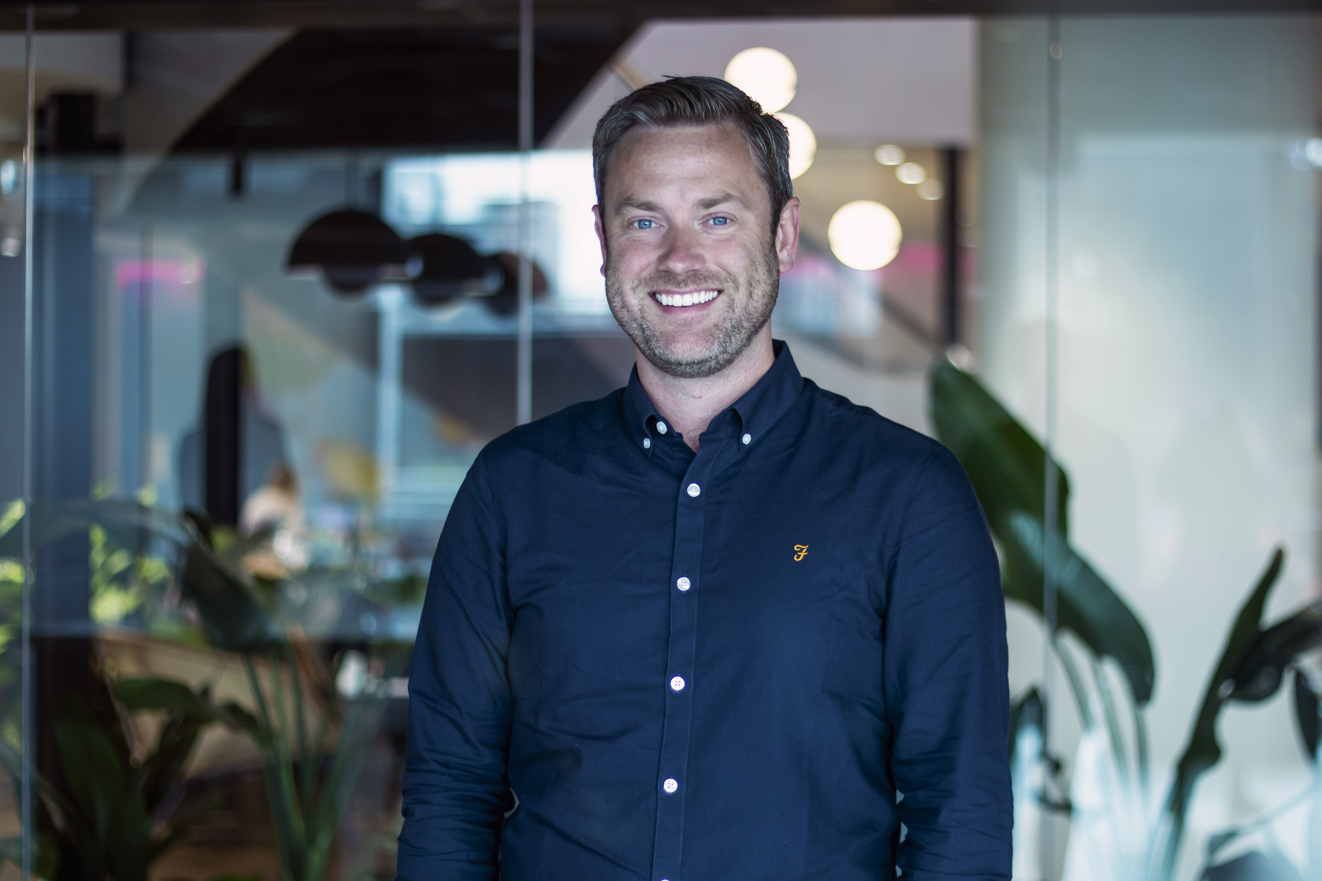 A professional headshot of Adrian Cross