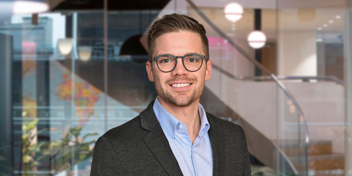 A professional headshot of Evan Kelly