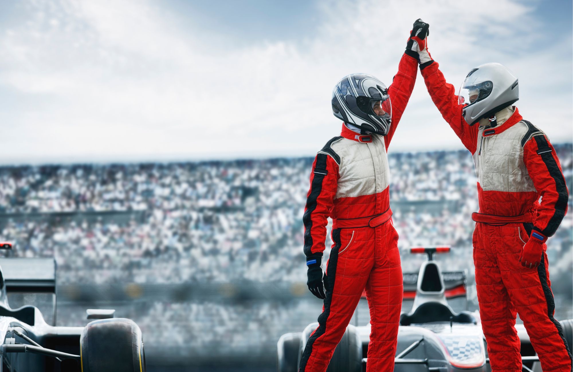 Two drivers high fiving on race course