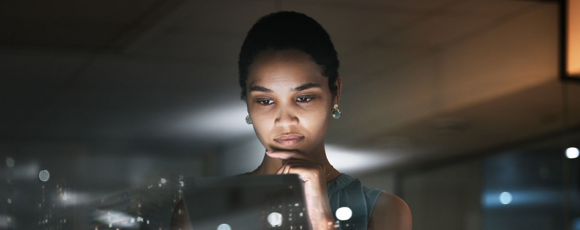 Woman looking at data on a tablet with overlay of city skyline