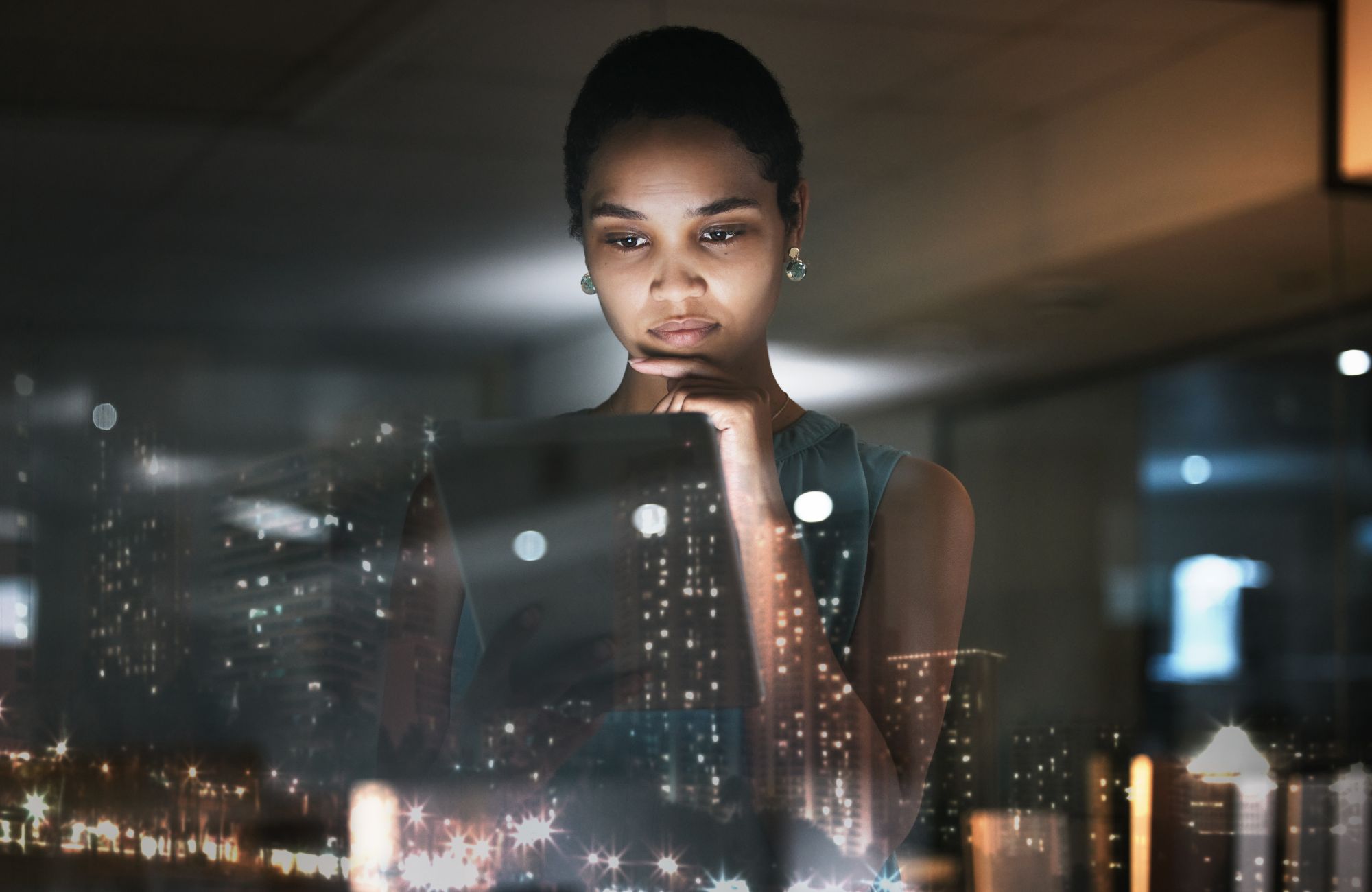 Woman looking at data on a tablet with overlay of city skyline